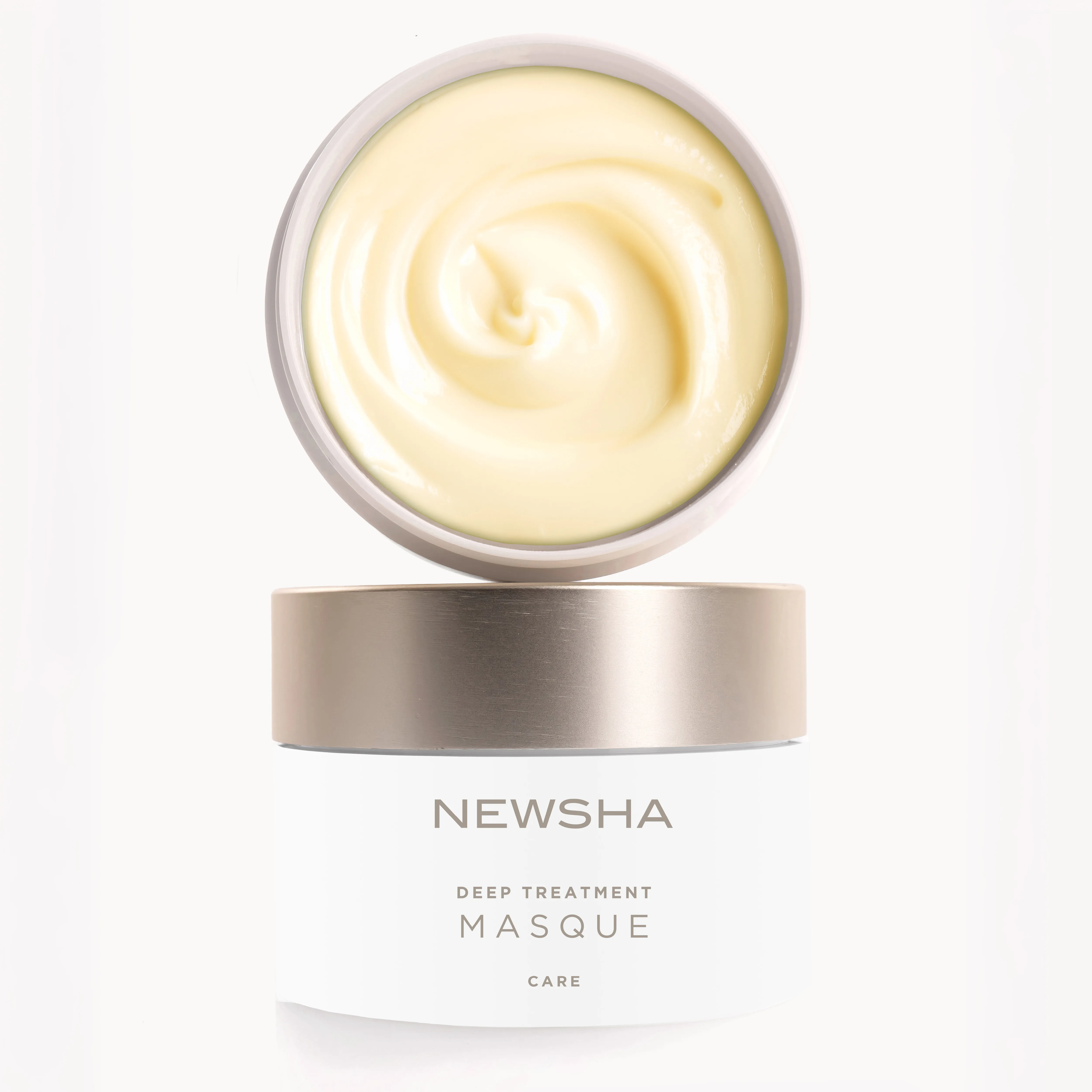 Ge&ouml;ffnete NEWSHA Deep Treatment Masque mit cremiger Textur und goldenem Deckel vor hellem Hintergrund.